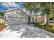 Street view of a well-maintained home featuring a two car garage and lovely landscaping at 12351 Ridgedale Dr, Hudson, FL 34669