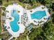 Overhead view of resort-style pools with water slides, lounge areas, and lush landscaping for relaxation and recreation at 17537 Brighton Lake Rd, Land O Lakes, FL 34638