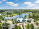 Scenic aerial view of the neighborhood with a tranquil lake, walking trails, and community buildings at 17537 Brighton Lake Rd, Land O Lakes, FL 34638