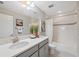 Bright bathroom featuring a shower-tub combo, marble counters, and decorative elements at 17537 Brighton Lake Rd, Land O Lakes, FL 34638