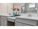 Bathroom featuring dual vanities, gray cabinetry, stone countertops, and a large mirror at 17537 Brighton Lake Rd, Land O Lakes, FL 34638