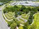Aerial view of community bike park with curved pavement, trees, and surrounding landscaping at 18172 Ramble On Way, Land O Lakes, FL 34638