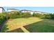 Well-maintained backyard with lush green grass, mature hedges, and neighboring homes in the distance at 18172 Ramble On Way, Land O Lakes, FL 34638