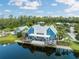 Beautiful aerial view of the waterfront clubhouse with a serene lake, surrounded by lush greenery and community amenities at 18172 Ramble On Way, Land O Lakes, FL 34638