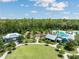 Aerial view of community amenities including a pool and clubhouse, surrounded by trees and greenery at 18172 Ramble On Way, Land O Lakes, FL 34638