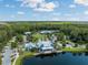 Community center featuring a clubhouse overlooking a lake amidst a serene forest setting at 18172 Ramble On Way, Land O Lakes, FL 34638