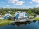 Exterior view of the community clubhouse showcasing a lakeside view, ample deck space, and manicured landscaping at 18172 Ramble On Way, Land O Lakes, FL 34638