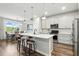 Bright kitchen featuring stainless appliances, white cabinets, island with seating, and dining area at 18172 Ramble On Way, Land O Lakes, FL 34638