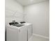 Functional laundry room equipped with a modern washer and dryer set and overhead shelving at 18172 Ramble On Way, Land O Lakes, FL 34638