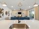 Bright open-concept living room featuring a brick accent wall and sliding glass doors to the outdoor patio at 18172 Ramble On Way, Land O Lakes, FL 34638