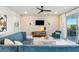 Cozy living room featuring a decorative brick wall, ceiling fan, comfortable seating, and natural light at 18172 Ramble On Way, Land O Lakes, FL 34638