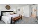 Bright main bedroom featuring a large bed, bench, and carpet flooring at 18172 Ramble On Way, Land O Lakes, FL 34638