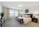 Bright main bedroom featuring a large bed, bench, and a window at 18172 Ramble On Way, Land O Lakes, FL 34638