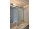 Bathroom vanity with a light above a large mirror and marble-style countertops at 1883 Clearbrooke Dr, Clearwater, FL 33760