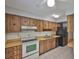 Kitchen with wooden cabinets, white appliances and tile flooring at 1883 Clearbrooke Dr, Clearwater, FL 33760