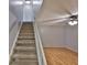 View of carpeted stairs and living room with wood floors and ceiling fan at 1883 Clearbrooke Dr, Clearwater, FL 33760
