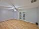 Spacious living room showcasing wood flooring and sliding doors, brightened by a ceiling fan at 1883 Clearbrooke Dr, Clearwater, FL 33760