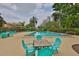Community pool area with turquoise lounge chairs and a table with chairs for relaxing by the pool at 1883 Clearbrooke Dr, Clearwater, FL 33760
