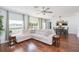 Spacious living room with hardwood flooring, large windows, and a view of the dining area at 19032 Malinche Loop, Spring Hill, FL 34610