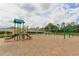 Green and tan playground equipment on a mulch base surrounded by a black fence at 19032 Malinche Loop, Spring Hill, FL 34610
