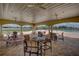 Seating under the veranda by the community pool with chairs, tables, and ceiling fans at 19032 Malinche Loop, Spring Hill, FL 34610