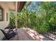 Outdoor balcony with iron railing, tile floor, patio furniture, and serene views of the lush greenery at 1966 Freedom Dr, Clearwater, FL 33755