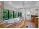 Luxurious bathroom with a large jacuzzi tub, tile surround, and large windows with views of the trees at 1966 Freedom Dr, Clearwater, FL 33755
