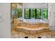 Gorgeous bathroom featuring a jetted tub, walk-in shower, and an outdoor nature view at 1966 Freedom Dr, Clearwater, FL 33755