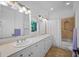 Bathroom with double sinks, granite countertops, and tub with shower at 1966 Freedom Dr, Clearwater, FL 33755