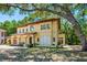 Mediterranean-style home with arched entryway and balcony, offering outdoor living space and lush surroundings at 1966 Freedom Dr, Clearwater, FL 33755