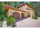 Lovely Mediterranean-style home with a two-car garage, complemented by mature landscaping and hardscape at 1966 Freedom Dr, Clearwater, FL 33755