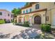 Close-up of the home's entry featuring an arched porch, columns, and a brick driveway at 1966 Freedom Dr, Clearwater, FL 33755