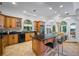 Spacious kitchen with wood cabinets, granite countertops, central island with bar seating, and arched windows offering ample natural light at 1966 Freedom Dr, Clearwater, FL 33755