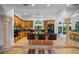 Bright kitchen boasts custom wood cabinets, granite countertops, central island with bar seating, and tiled floors at 1966 Freedom Dr, Clearwater, FL 33755