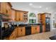 Bright kitchen features wood cabinets, granite countertops, modern appliances, and a large arched window at 1966 Freedom Dr, Clearwater, FL 33755