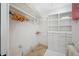 Well-organized walk-in closet with custom shelving, drawers, tile floors, and hanging racks at 1966 Freedom Dr, Clearwater, FL 33755
