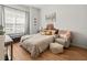 Bright bedroom with a large window, wood flooring, a chair and ottoman, and a padded headboard at 19808 Sunsplash Ln, Lutz, FL 33558