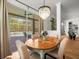 Dining room with a chandelier, dining table with 4 chairs, and a sliding glass door view of the pool at 19808 Sunsplash Ln, Lutz, FL 33558