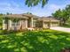 Landscaped front yard with a well-maintained lawn and mature trees enhance this single-story home at 19808 Sunsplash Ln, Lutz, FL 33558