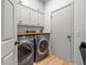 Well-organized laundry room with front load washer and dryer, wood countertop, and storage cabinets at 19808 Sunsplash Ln, Lutz, FL 33558