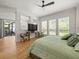 Bright bedroom featuring wood floors, ceiling fan, sitting area, and sliding glass door to the lanai at 19808 Sunsplash Ln, Lutz, FL 33558