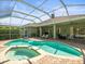 This backyard boasts a sparkling pool, spa, and screened enclosure with a covered patio for outdoor relaxation at 19808 Sunsplash Ln, Lutz, FL 33558