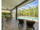 Relaxing pool area with covered patio, ceiling fan, sun loungers, and lush green surroundings at 19808 Sunsplash Ln, Lutz, FL 33558