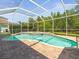 Beautiful screened pool with brick pavers, lush greenery, and clear blue water at 19808 Sunsplash Ln, Lutz, FL 33558