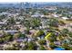 Aerial view of a residential area with mature trees and glimpses of Tampa Bay's skyline in the distance at 212 W Floribraska Ave, Tampa, FL 33603