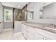 Bathroom features white cabinets, granite counters, double sinks, and glass shower with stone surround at 212 W Floribraska Ave, Tampa, FL 33603