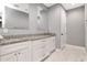 Bright bathroom with white cabinets, granite counters, double sinks, and sleek marble tile floor at 212 W Floribraska Ave, Tampa, FL 33603