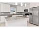 Modern kitchen featuring white cabinets, stainless steel appliances, granite countertops, and a kitchen island with pendant lights at 212 W Floribraska Ave, Tampa, FL 33603