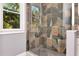 Shower with glass door and colorful stone-look tile surround at 212 W Floribraska Ave, Tampa, FL 33603
