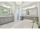 Elegant bathroom with dual vanities, a soaking tub, and marble flooring, creating a serene and stylish atmosphere at 2604 S Bryant Cir, Tampa, FL 33629